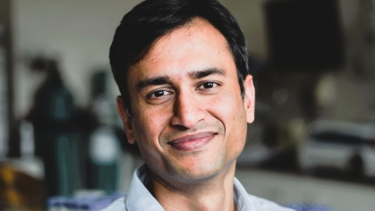 head shot of male with dark short hair wearing a blue button down collared shirt