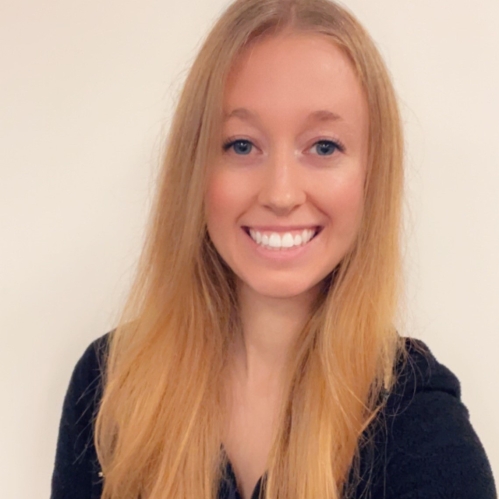 Head shot of smiling female with long blond hair wearing a black sweater.