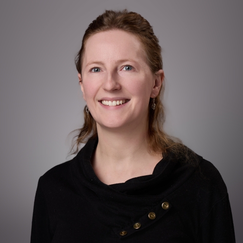 Headshot of woman with light red hair wearing black sweater.