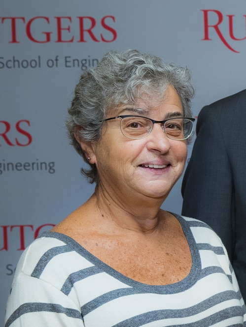 head shot of women with short grey hair wearing glasses and a striped white and blue shirt