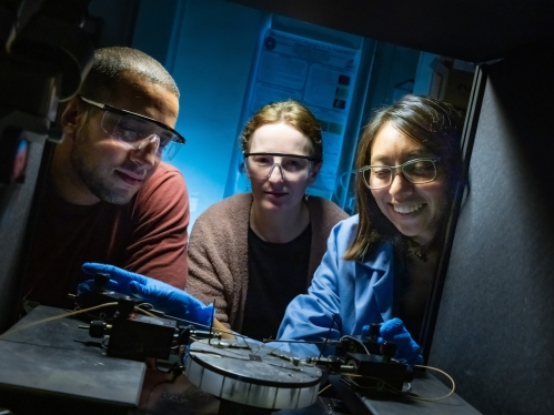 In the center of the photo, a female professor instructs a female student and a male student in her lab.