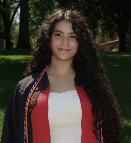 Young woman with long dark hair wearing regalia over a white shirt